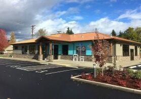 Exterior view of a modular building company office with stone accents and fresh landscaping