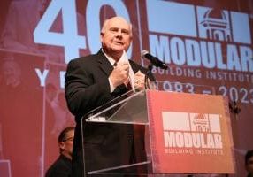 Roland Brown addresses the crowd at the 2023 World of Modular following his induction into MBI’s modular construction industry Hall of Fame.