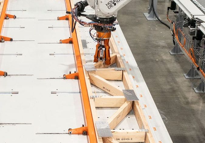 A robot programmed by House of Design assembles a truss for a modular building